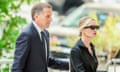 Man in suit and woman in shirt and sunglasses arrive at court
