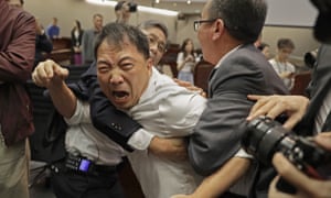 A pro-democracy lawmaker scuffles with security guards