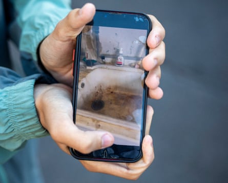 A student shows an image of a dirty sink on a phone