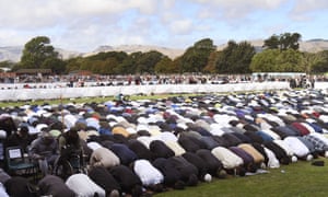 People pray during two minutes of silence for victims at Hagley Park in Christchurch on Friday.