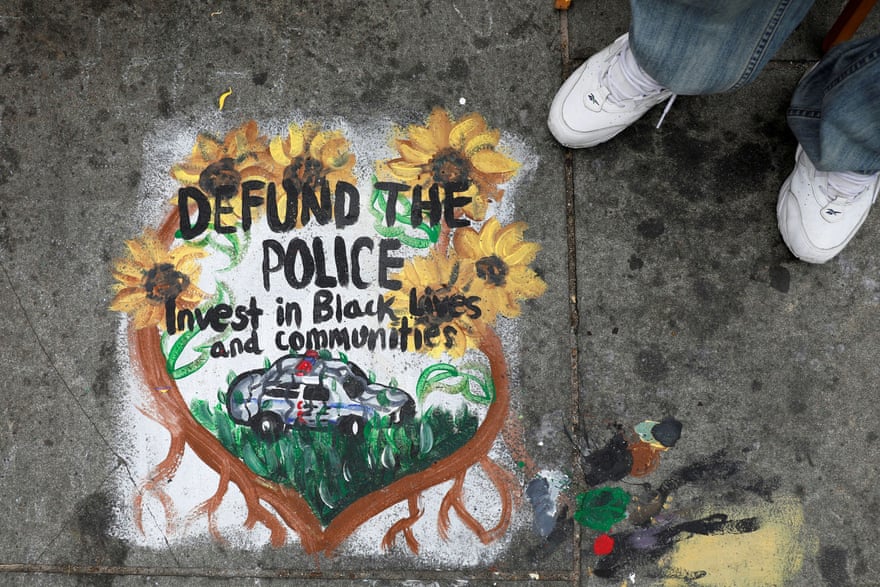 painting says 'defund the police - invest in black lives and communities'