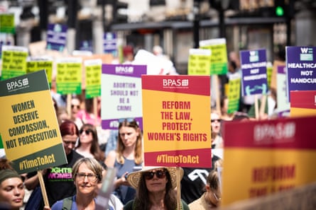 Protesters march with placards saying 'Women deserve compassion, not prosecution' and 'Reform the law, protect women's rights'