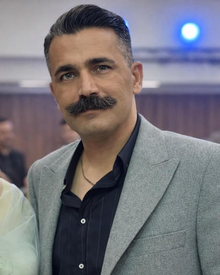 A middle-aged man with a moustache wearing a jacket