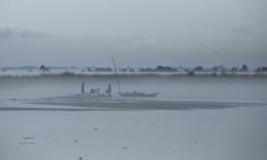 Indian villagers salvage logs of wood brought by floodwaters. The Brahmaputra river has burst its banks in many places and has been at danger levels for weeks.