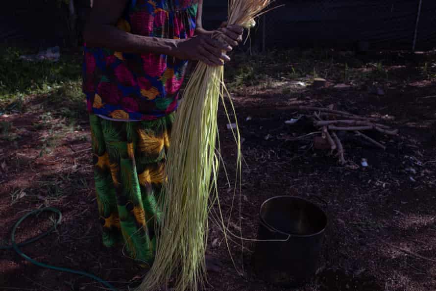 'Bringing the sun in': Bula'Bula's hardworking weavers dig color out of the red soil | native art Evonne puts the split pandanus in a pot to cook on the fire with djundom to start the dyeing process