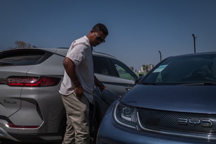 A man standing between two cars outside