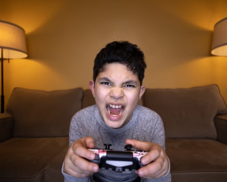 A kid looks angry as he plays a video game.