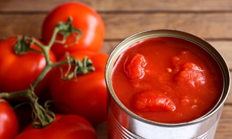 Open tin of chopped tomatoes with fresh tomatoes next to it