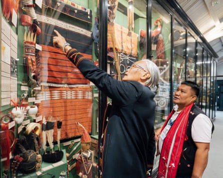 Two south-east Asian men point at some exhibits in a museum