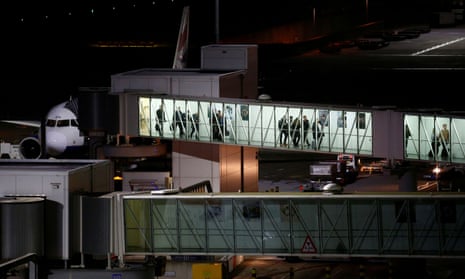 People disembark from an aircraft at Heathrow airport