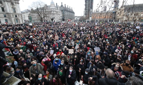 A large crowd of people holding placards gather in Parliament Square in London on Sunday, the day after clashes between police and crowds who gathered on Clapham Common on Saturday night to remember Sarah Everard.