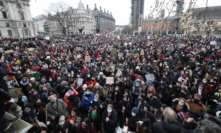 A large crowd of people holding placards gather in Parliament Square in London on Sunday, the day after clashes between police and crowds who gathered on Clapham Common on Saturday night to remember Sarah Everard.