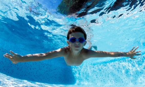 Boy swimming underwater with goggles