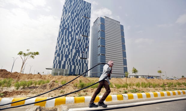 A labourer pulls cable in front of office buildings in Gujarat International Finance Tec-City at Gandhinagar.