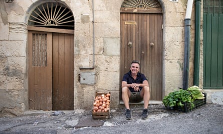 Danny McCubbin sitting on a doorstep outside the house in Sicily that he bought for €1.