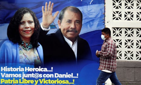 A man walks past a banner depicting  Daniel Ortega and Rosario Murillo  in Managua, Nicaragua.