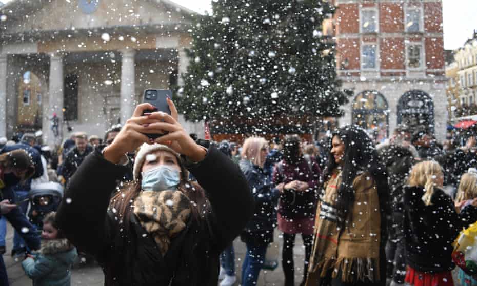 Daily life in London amid coronavirus pandemicepa09631833 A woman photographs artificial snow in Covent Garden in London, Britain, 09 December 2021. Britain's government has announced new Covid-19 rules, including working from home if possible. Starting Friday 10 December, face masks will be mandatory for most indoor public venues as well as on public transport. EPA/NEIL HALL