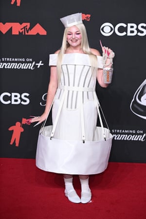 Comedian Megan Stalter is unafraid of appearing Too Much in a pill box hat, corset, suspended skirt and bejewelled coffee cup.