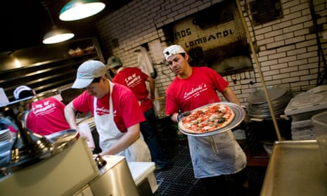 View of kitchen workers preparing pizza in Lombardi s pizzeria in the the Little Italy neighbourhood of New York City.