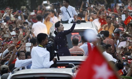 Aung San Suu Kyi   waves to supporters from the back of an open vehicle