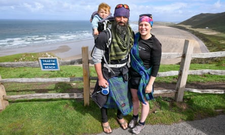 Chris Lewis with Kate Barron and their son, Magnus, walking towards the finish line at Llangennith beach