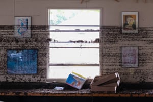 Frames hang from a wall with flood marks