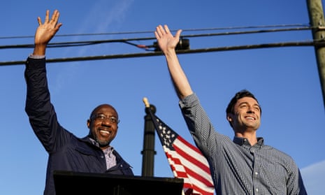Rev. Raphael Warnock, left, and Jon Ossoff, right, gesture toward a crowd during a campaign rally in Marietta, Georgia.