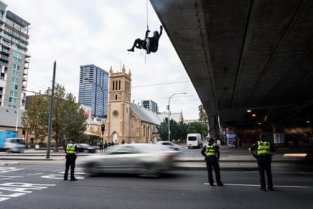 A woman abseils over a bridge in Adelaide during an Extinction Rebellion protest on 18 May.