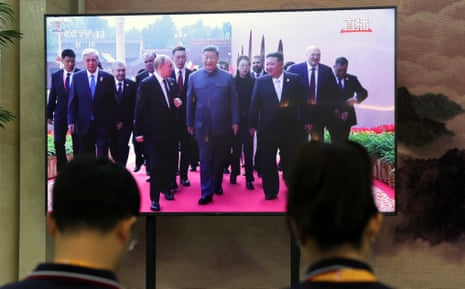 A TV screen shows Chinese leader Xi Jinping, Russian president Vladimir Putin and North Korea’s Kim Jong Un arriving for the military parade.
