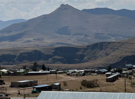 Single-storey buildings on a flat area of land with mountainous terrain behind