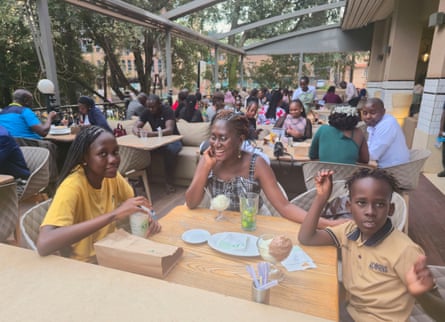 a mother and her children enjoy snacks at a cafe in kampala