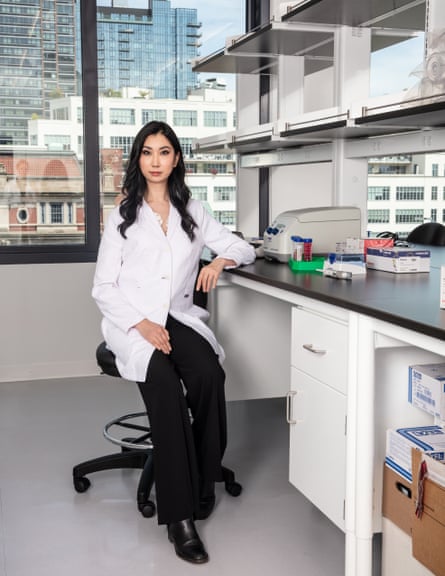 Gene technology entrepreneur Cathy Tie sitting at a desk in a white lab coat