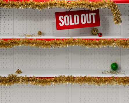 Empty shop shelves decorated with tinsel and displaying a red sold out sign