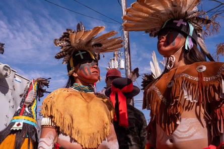 Dancers wearing fringed tops and feathered headpieces