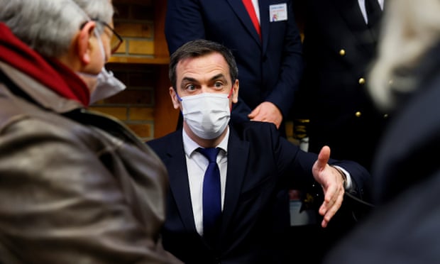 Olivier Véran, the French health minister, speaks to people waiting to receive a Covid vaccine