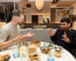 Peter and Akshat chatting and gesticulating at a restaurant table