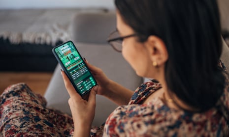 Stock image of a woman gambling using her mobile phone