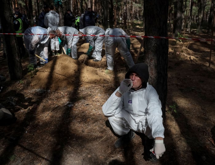 Man in hazmat suit rests in forest