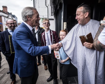 Farage shakes hands with a man at a barber’s shop