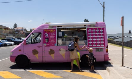 A mother and child buying ice-cream from a pink van