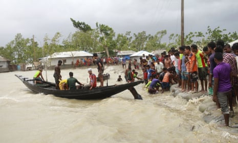 A boat brings people to land as flooding from Cylcone Amphan hit coastal areas in Bangladesh and India. 