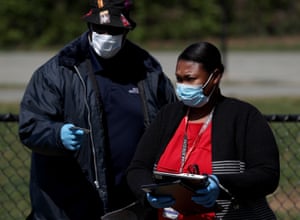 A teacher in Maryland, US, handing out computers to students for remote learning.