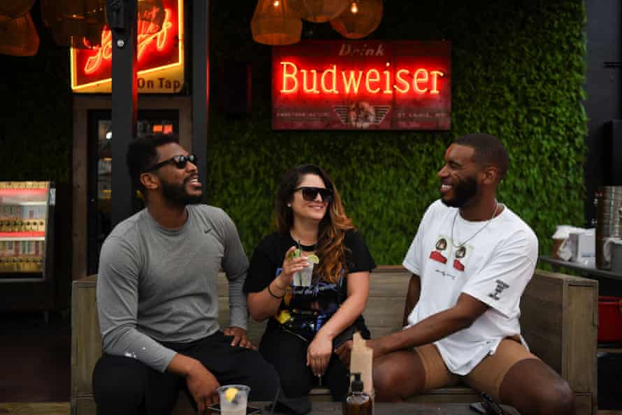 People share a drink on the patio at Bar 5015 as the state of Texas lifts its mask mandate.