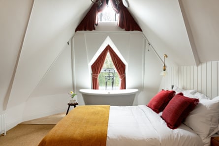 A double room with a bath by a window in a hotel.