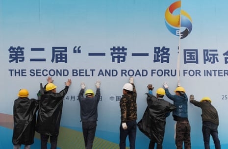Workers take down a Belt and Road Forum panel  in Beijing in 2019.  