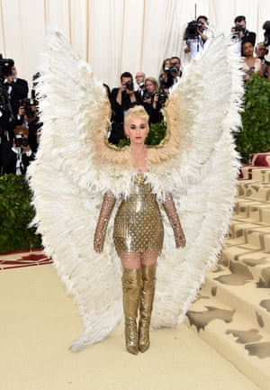 Heavenly = angel wings, right? Katy Perry arrived wearing a giant pair of feathered wings with her gold chainmail Versace mini dress and thigh-high boots. The singer and American Idol judge paused for a moment on the red carpet to kneel in prayer - perhaps hoping for divine guidance on how to sit down with those wings.