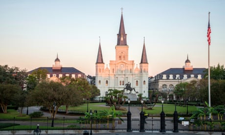 the exterior of a large church surrounded by greenery