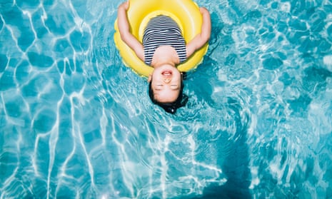 young girl eyes closed floating with an inflatable ring at swimming pool