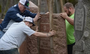 Volunteers from a local monument company help to reset vandalized headstones at Chesed Shel Emeth Cemetery in Missouri.