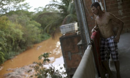 A resident is pictured on the balcony of his house on the banks of Rio Doce after a dam, owned by Vale and BHP Billiton, burst.